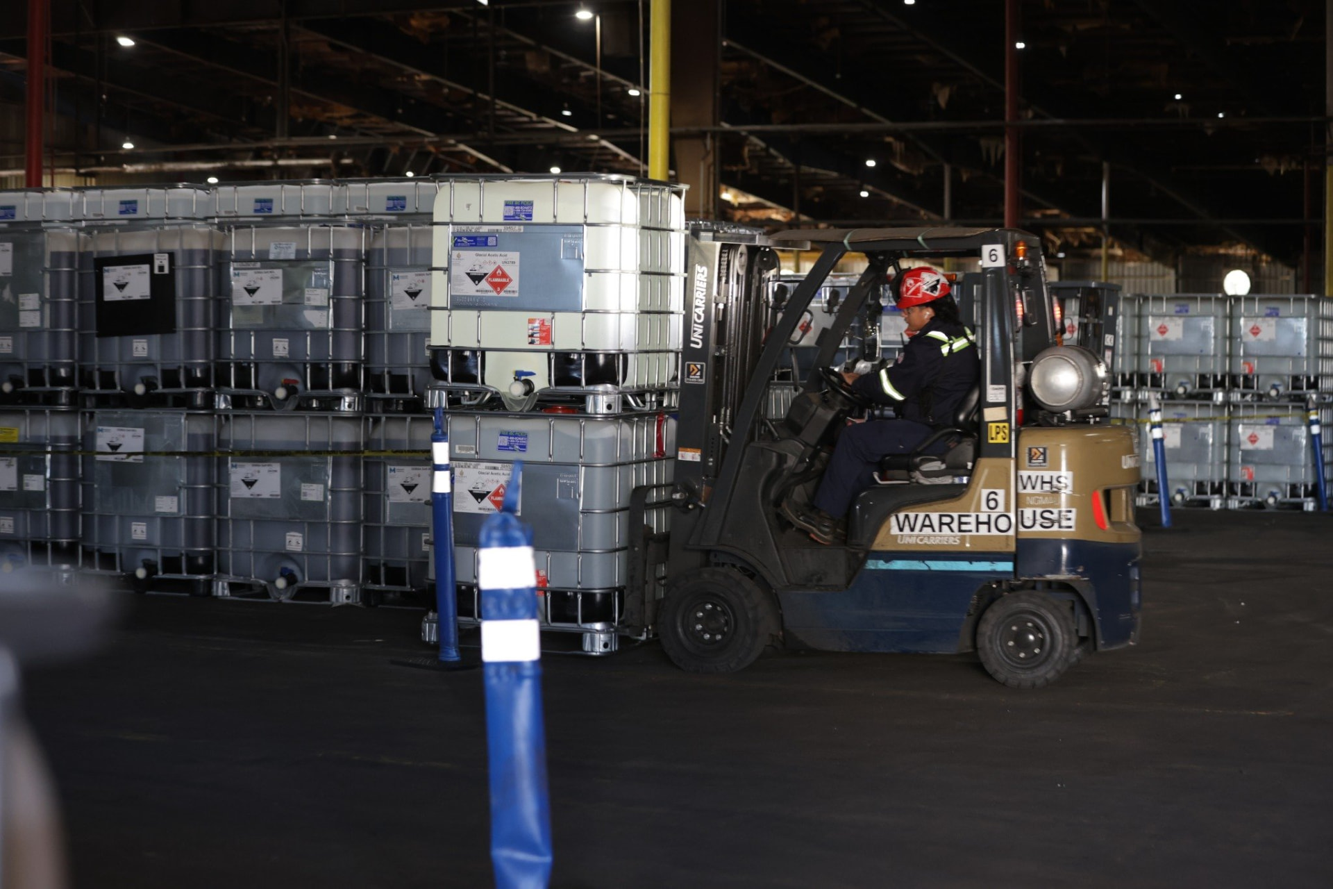 Warehouse operator moving chemical totes at the Element Chemicals facility